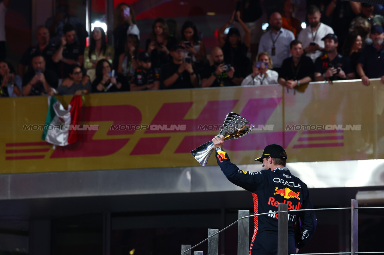 GP ABU DHABI, Gara winner Max Verstappen (NLD) Red Bull Racing celebrates on the podium.

26.11.2023. Formula 1 World Championship, Rd 23, Abu Dhabi Grand Prix, Yas Marina Circuit, Abu Dhabi, Gara Day.

 - www.xpbimages.com, EMail: requests@xpbimages.com © Copyright: Coates / XPB Images