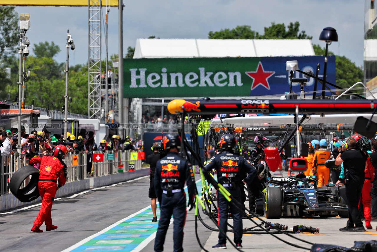 GP CANADA, George Russell (GBR) Mercedes AMG F1 W14 makes a pit stop to fix damage as a Ferrari mechanic collects an errant wheel carcass.

18.06.2023. Formula 1 World Championship, Rd 9, Canadian Grand Prix, Montreal, Canada, Gara Day.

- www.xpbimages.com, EMail: requests@xpbimages.com © Copyright: Batchelor / XPB Images