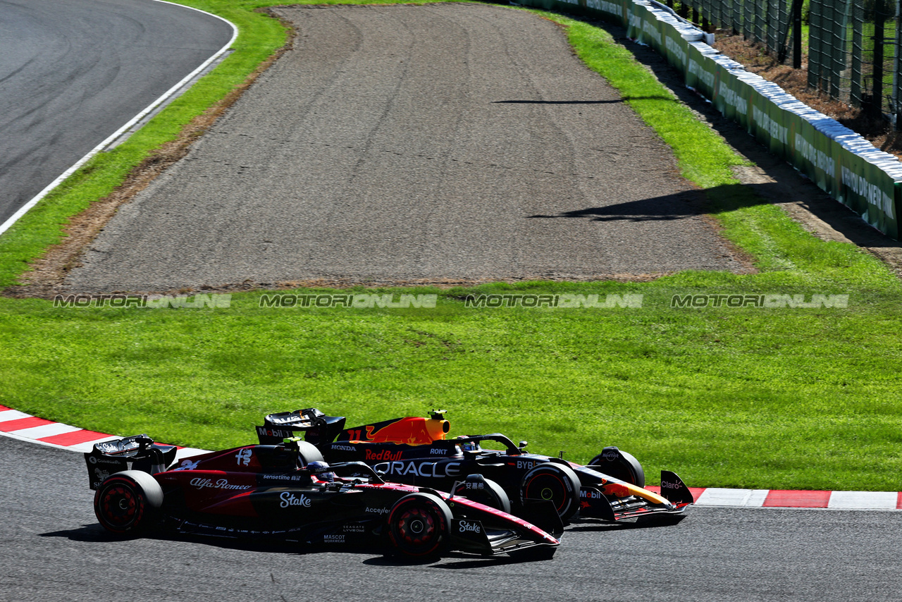 GP GIAPPONE, Sergio Perez (MEX) Red Bull Racing RB19 e Zhou Guanyu (CHN) Alfa Romeo F1 Team C43 battle for position.

24.09.2023. Formula 1 World Championship, Rd 17, Japanese Grand Prix, Suzuka, Japan, Gara Day.

 - www.xpbimages.com, EMail: requests@xpbimages.com © Copyright: Coates / XPB Images