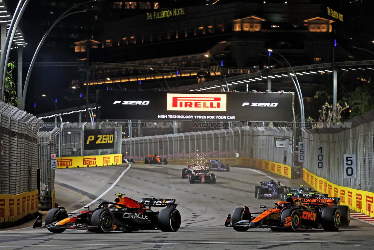 GP SINGAPORE, Sergio Perez (MEX) Red Bull Racing RB19 e Lando Norris (GBR) McLaren MCL60 battle for position.

17.09.2023. Formula 1 World Championship, Rd 16, Singapore Grand Prix, Marina Bay Street Circuit, Singapore, Gara Day.

- www.xpbimages.com, EMail: requests@xpbimages.com © Copyright: Bearne / XPB Images