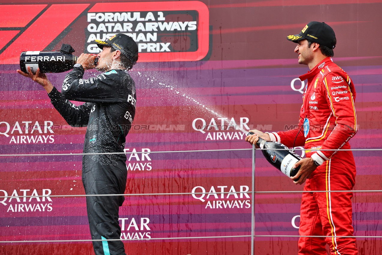 GP AUSTRIA, (L to R): Gara winner George Russell (GBR) Mercedes AMG F1 celebrates on the podium with third placed Carlos Sainz Jr (ESP) Ferrari.

30.06.2024. Formula 1 World Championship, Rd 11, Austrian Grand Prix, Spielberg, Austria, Gara Day.

- www.xpbimages.com, EMail: requests@xpbimages.com © Copyright: Batchelor / XPB Images