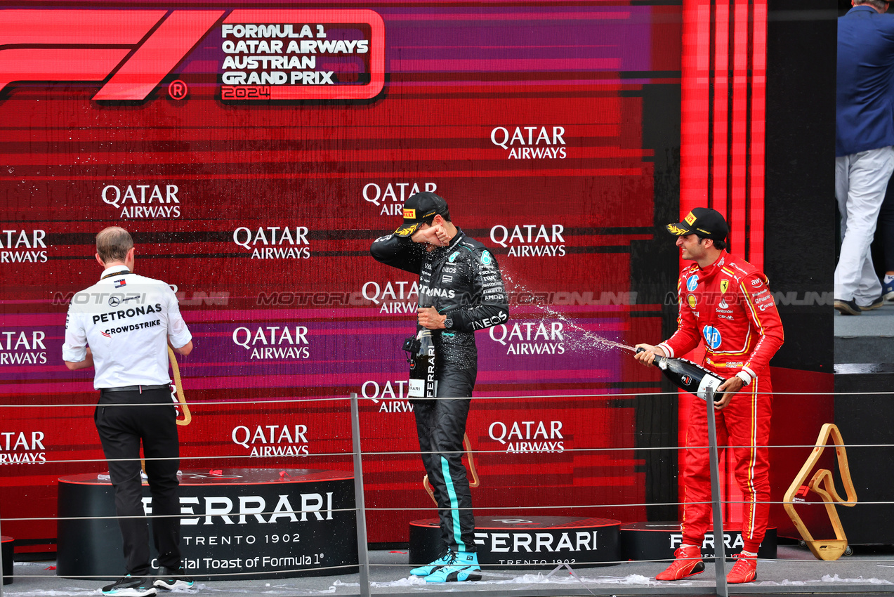 GP AUSTRIA, Gara winner George Russell (GBR) Mercedes AMG F1 celebrates on the podium with Carlos Sainz Jr (ESP) Ferrari e Marcus Dudley (GBR) Mercedes AMG F1 Gara Engineer.

30.06.2024. Formula 1 World Championship, Rd 11, Austrian Grand Prix, Spielberg, Austria, Gara Day.

- www.xpbimages.com, EMail: requests@xpbimages.com © Copyright: Charniaux / XPB Images