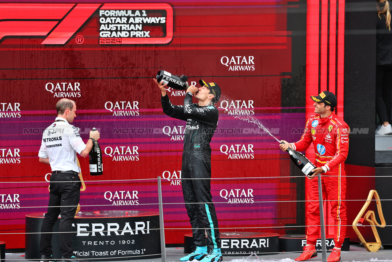 GP AUSTRIA, Gara winner George Russell (GBR) Mercedes AMG F1 celebrates on the podium with Carlos Sainz Jr (ESP) Ferrari e Marcus Dudley (GBR) Mercedes AMG F1 Gara Engineer.

30.06.2024. Formula 1 World Championship, Rd 11, Austrian Grand Prix, Spielberg, Austria, Gara Day.

- www.xpbimages.com, EMail: requests@xpbimages.com © Copyright: Charniaux / XPB Images