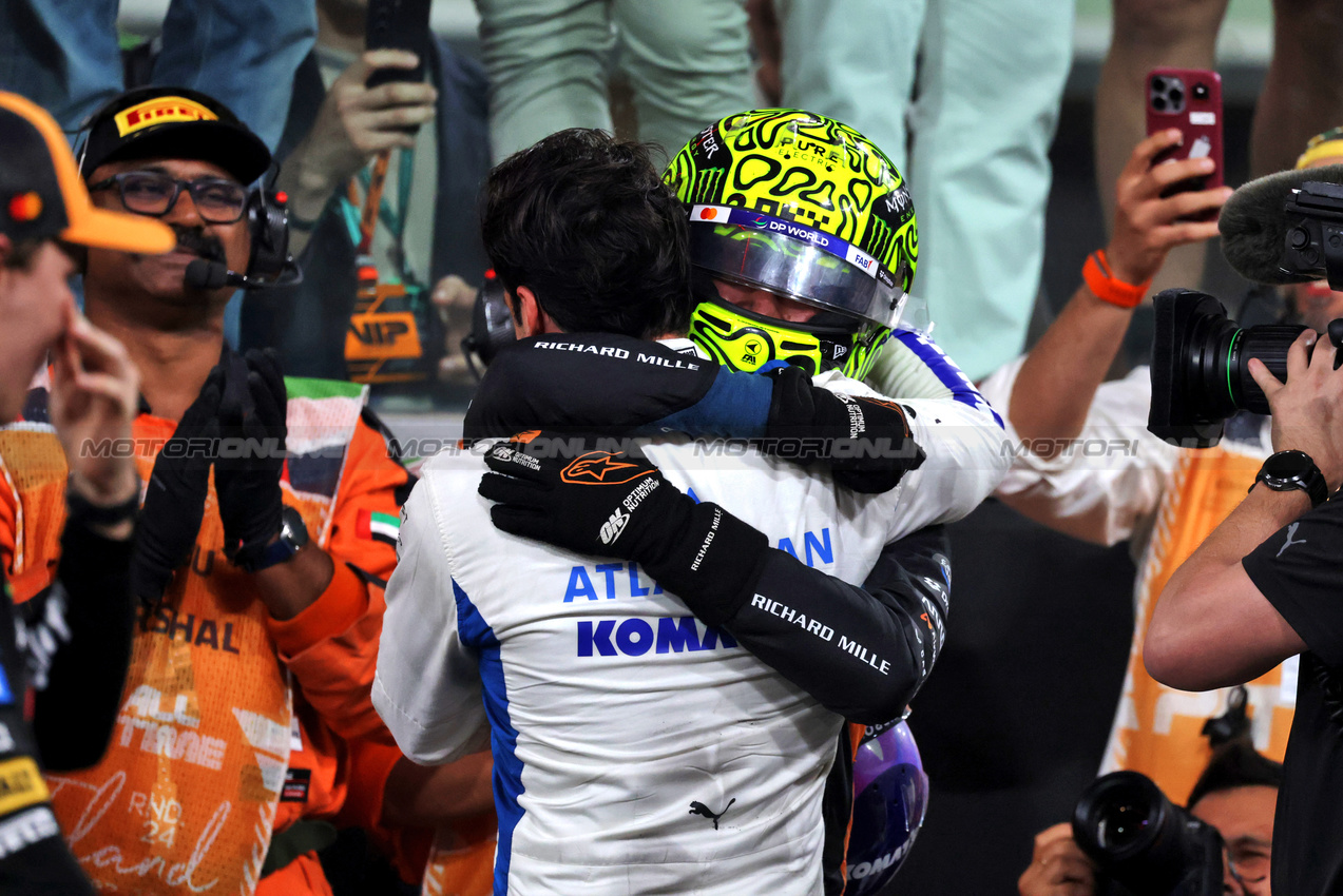 GP ABU DHABI, Third placed World Champion Lando Norris (GBR) McLaren celebrates with Carlos Sainz (ESP) Atlassian Williams Racing in parc ferme.

07.12.2025. Formula 1 World Championship, Rd 24, Abu Dhabi Grand Prix, Yas Marina Circuit, Abu Dhabi, Gara Day.

- www.xpbimages.com, EMail: requests@xpbimages.com © Copyright: Moy / XPB Images