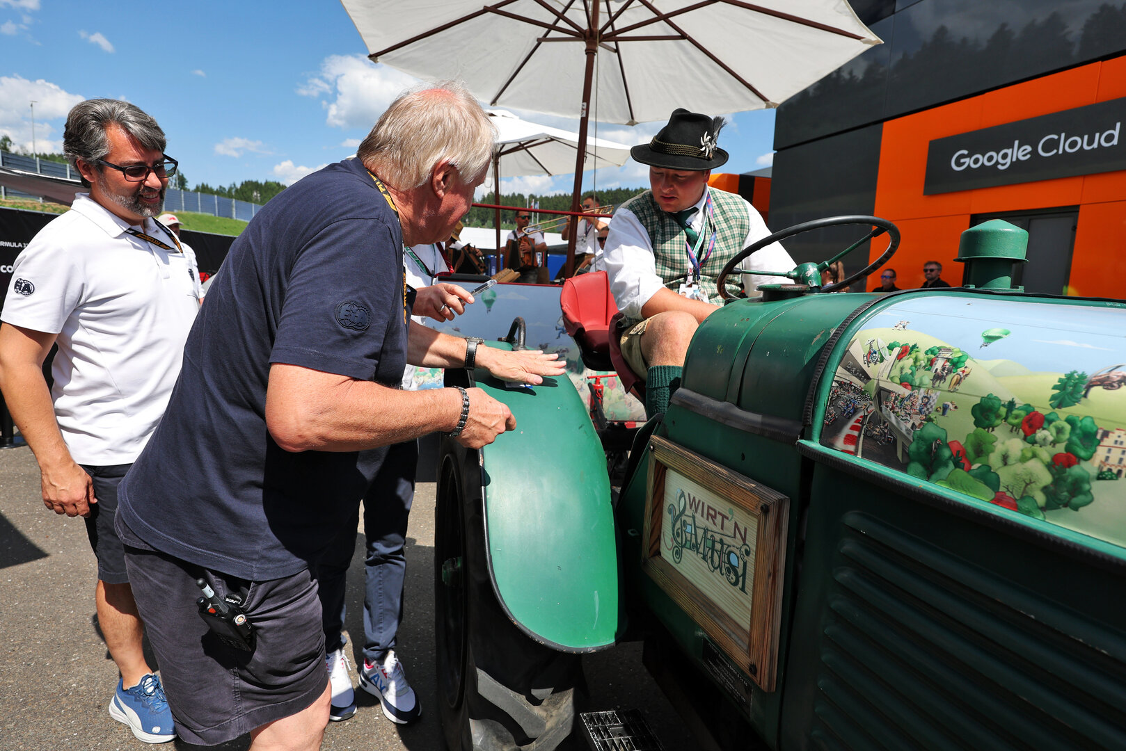 GP AUSTRIA, Jo Bauer (GER) FIA Delegate with the paddock tractor e trailer driver.
25.06.2026. Formula 1 World Championship, Rd 8, Austrian Grand Prix, Spielberg, Austria, Preparation Day.
- www.xpbimages.com, EMail: requests@xpbimages.com © Copyright: Moy / XPB Images