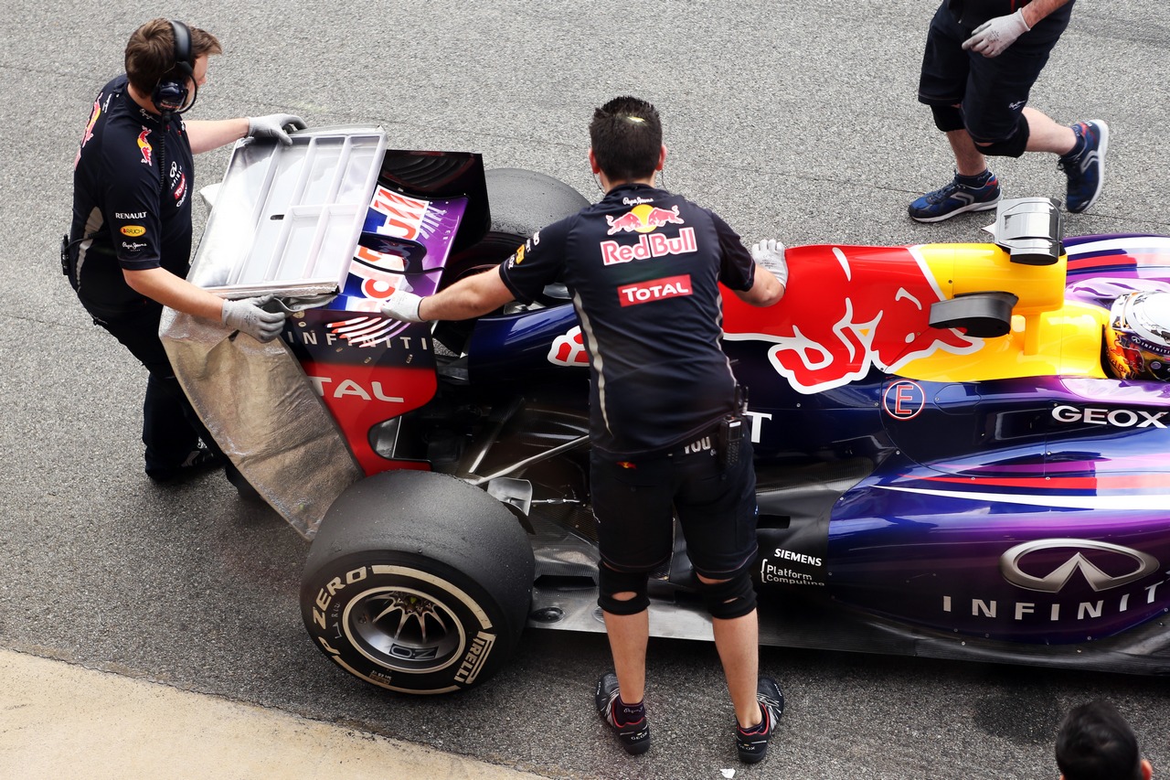 Sebastian Vettel (GER) Red Bull Racing RB9 with rear wing covered by a mechanic.

