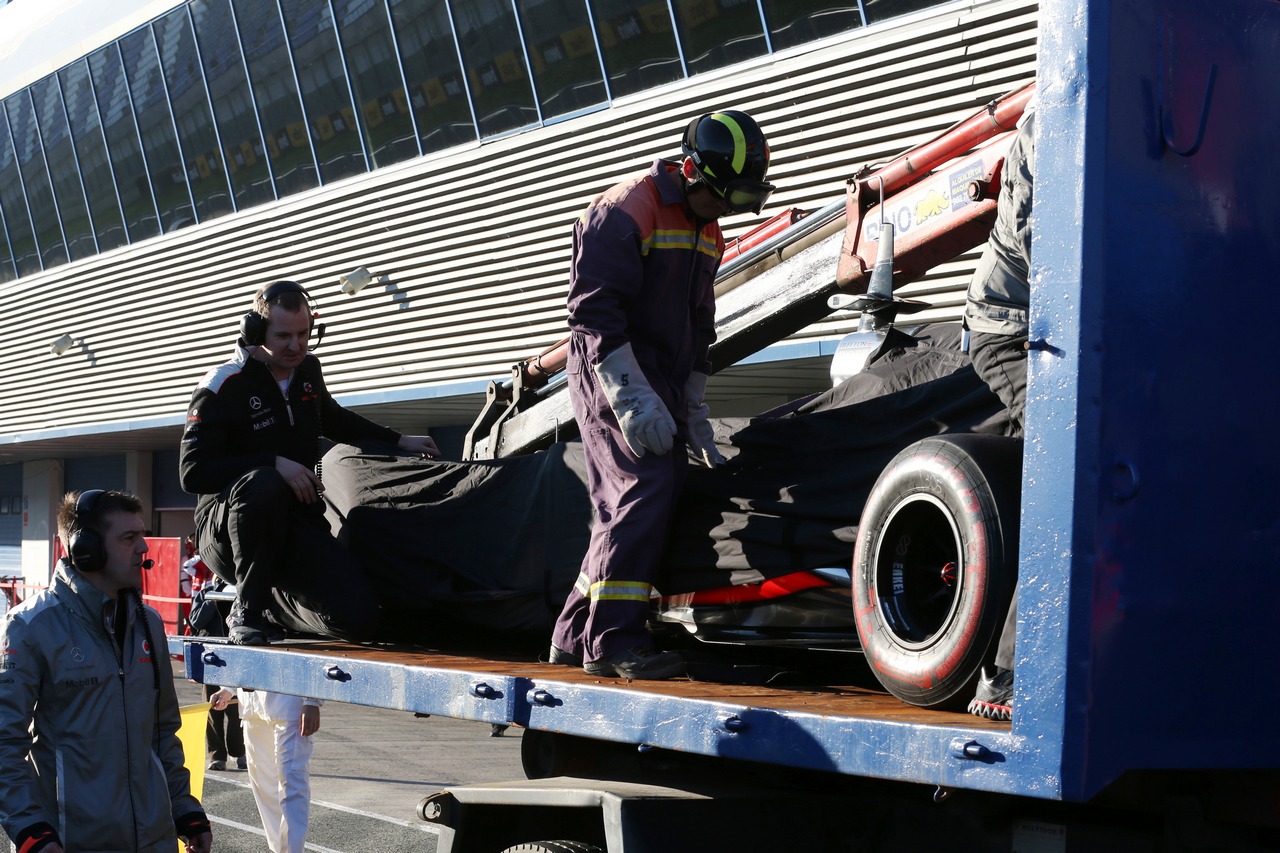 The McLaren MP4-28 is recovered back to the pits on the back of a truck.
